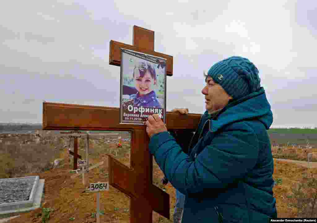 Iryna Orfinyak at the grave of her granddaughter, Veronika, in the Starokrymske cemetery in the northwest of Mariupol on November 9. The child was killed alongside her father when a mortar round landed among a huddle of people cooking outside during the Russian siege of the city. 