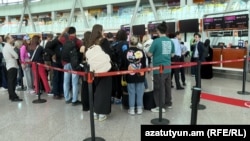 People line up at check-in desks at the airport in Zvartnots, west of Yerevan, in April.
