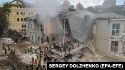 Ukrainians work at the site of a missile strike on a children's hospital in Kyiv on July 8.