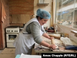 A woman in Abovyan, who fled her home in Stepanakert in September 2023, rolls dough for jingalov hats. In and around the central market of Abovyan, at least three separate businesses run by Karabakh Armenian refugees sell the traditional dish.