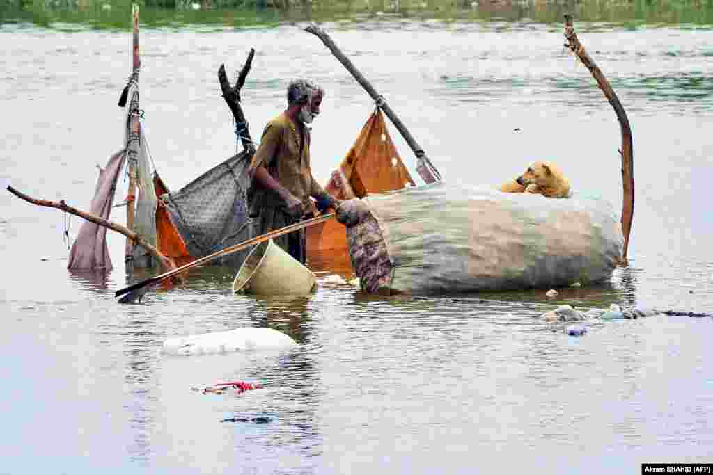 A man gathers his belongings from a bamboo tent, partially submerged in floodwaters, after heavy monsoon rains in Hyderabad, Sindh Province. Authorities have warned that ongoing heavy rain, which began last month, could cause landslides and flash floods across Pakistan. 