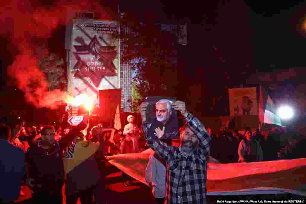 An Iranian man holds a poster of senior Iranian military commander General Qassem Soleimani during a celebration after the IRGC attack on Israel. Soleimani was killed by a U.S. drone strike near Baghdad International Airport on January 3, 2020, while travelling to meet Iraqi Prime Minister Adil Abdul-Mahdi.