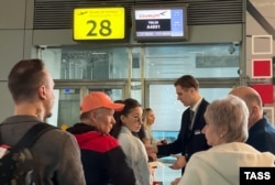 Passengers line up to board the inaugural flight to Tbilisi at Vnukovo International Airport in Moscow.