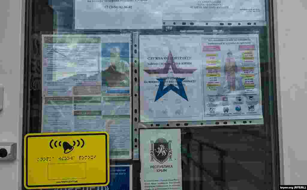 The Alushta bus station's doors are decorated with advertising seeking fresh recruits for the Russian military.