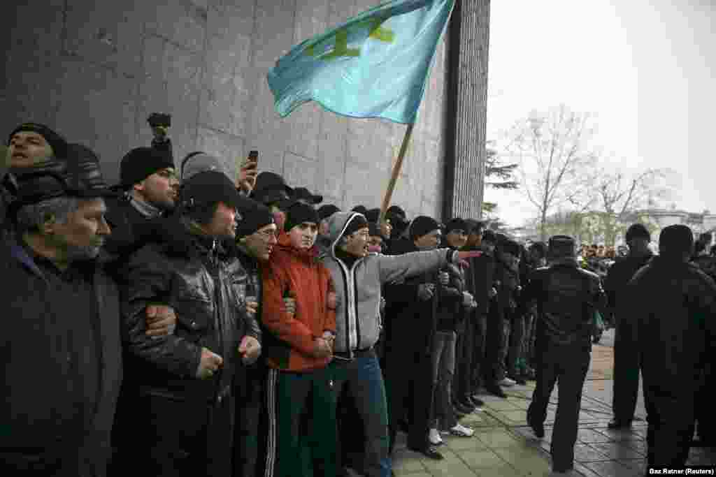 Crimean Tatars hold the flag of their people during a rally at the Crimean parliament in Simferopol on February 26, 2014. One week earlier, a Crimean politician raised the possibility of the peninsula’s “secession” from Ukraine. Kyiv street protesters at the time were in the process of ousting pro-Russian President Victor Yanukovych from power in what Ukrainians came to call the “revolution of dignity.” 