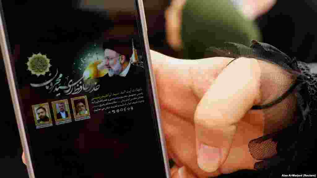 An Iranian Shi'ite pilgrim in the holy city of Najaf, Iraq, shows the news on her phone announcing the death of Raisi. The ultraconservative Raisi was widely tipped to become the country's next supreme leader.