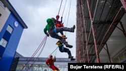 Vullnetarët duke u lëshuar me litarë nga kati më i lartë i Klinikës së Pediatrisë në Prishtinë.
