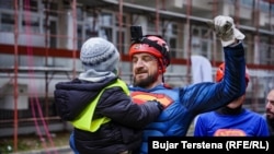 Berat Rexhepaj mban në krahë një fëmijë pas lëshimit më litarë në Klinikën e Pediatrisë në QKUK.