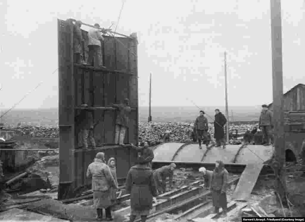 An image titled Donbas Heals Its Wounds shows workers repairing equipment at the Dzerzinsky coal mine. The Donbas was occupied by Nazi and Italian forces from 1941 until 1943. Most photos in this gallery were taken between 1944 and 1949. 