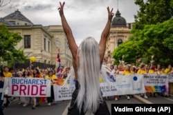 A participant flashes victory signs during a Pride parade in Bucharest on July 29.