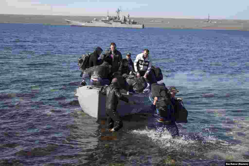 Crew members of the Ukrainian naval warship Konstantin Olshansky, which was blockaded by Russian warships, arrive on shore after leaving their ship on March 23. The ship was later seized and incorporated into the Russian Navy. 