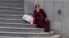Garryja aýal döwlet binasynyň öňünde otyr. Aşgabat (Illýustrasiýa suraty) 