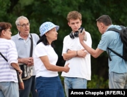 Nikola Andonov (second right) speaks with protesters who are watching over the monument.