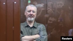 Igor Girkin sits behind a glass wall of an enclosure for defendants before a court hearing in Moscow on July 21.