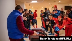 Një gjashtëvjeçar përshëndetet nga vullnetarët e Klubit Alpin Prishtina, të veshur në kostume të superheronjve, në repartin e Onkologjisë pediatrike në Prishtinë.