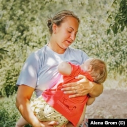 A Maryinka resident breastfeeds her child in summer 2018.