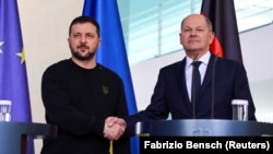 German Chancellor Olaf Scholz (right) and Ukrainian President Volodymyr Zelenskiy shake hands at a press conference in Berlin in February.