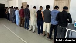 Pakistanis arrested for illegally working in Kyrgyzstan are lined up by police in Bishkek on May 15.