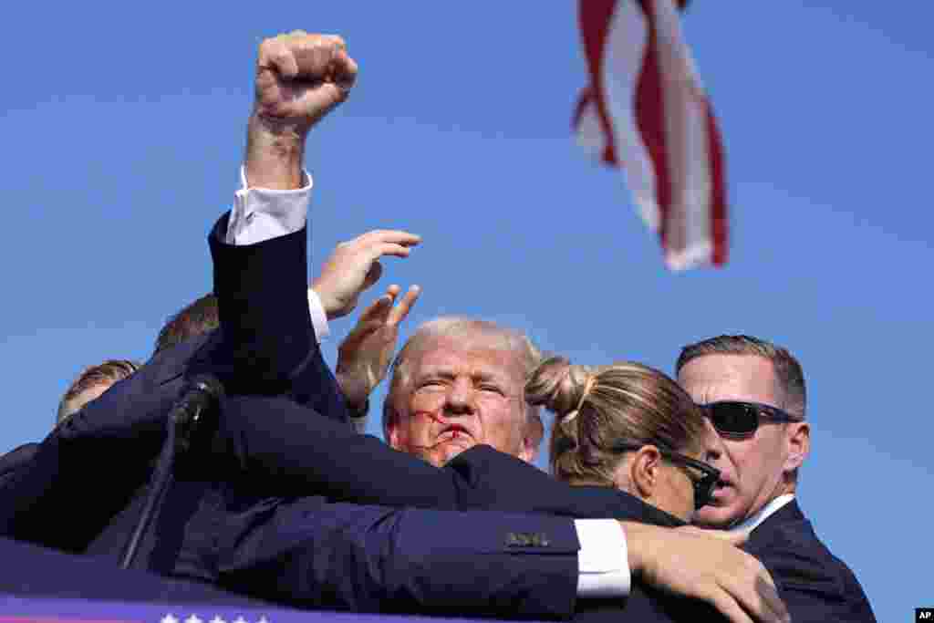 As he was being led off of the stage, Trump turned toward the crowd, pumped his fist in the air and appeared to yell, "Fight, fight, fight!"