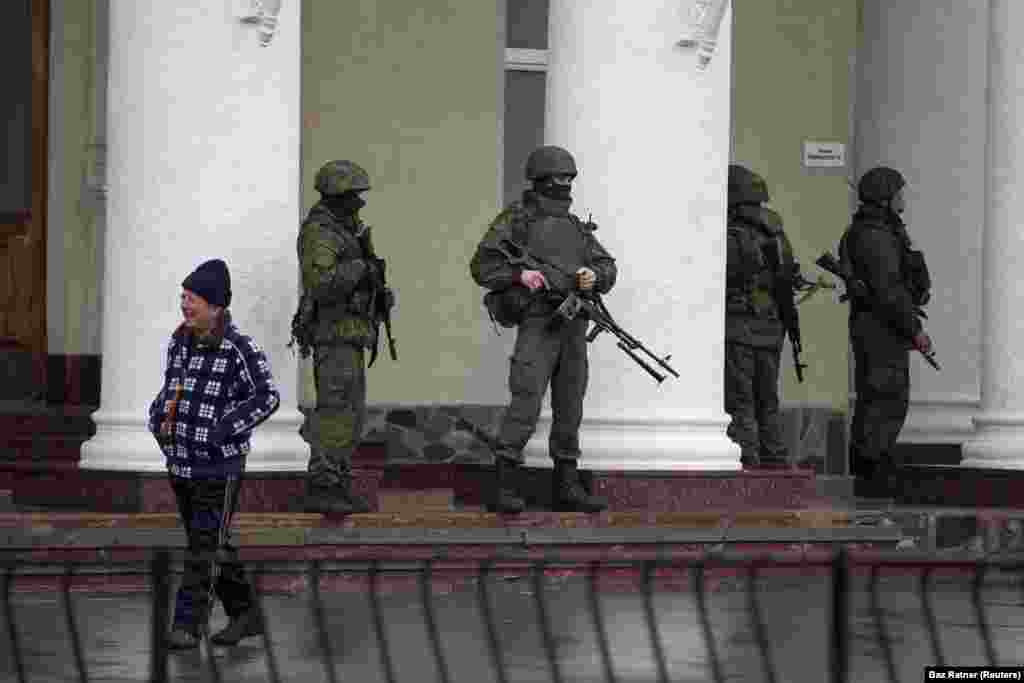 Russian soldiers operating without insignia stand outside the Simferopol airport on February 28. Incognito Russian soldiers appeared throughout Crimea and became known as “little green men.” The Kremlin initially claimed the soldiers were local “self-defense” groups but later admitted they were professional Russian soldiers. 
