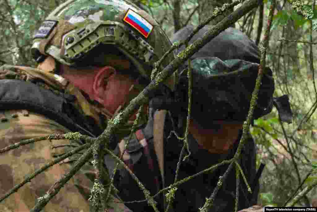 A fighter wearing a Russian flag with another soldier during the joint exercises. The Kremlin weighed in on July 20, with spokesman Dmitry Peskov telling reporters that Poland's relocation of troops to its eastern border was "a cause for concern," adding that what he called "the aggressiveness of Poland is a reality." 