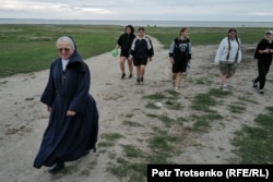 Visitors to the children's camp are shown the way by a nun.