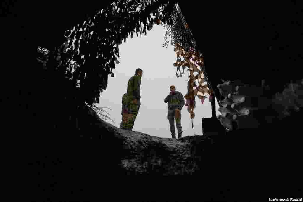 Ukrainian soldiers enjoy a cigarette break near the entrance to their dugout during a lull in fighting near Bakhmut on December 15. Prior to Tarnavskiy's remarks, Kyiv had said its forces had no intention of letting up the fight and would soldier on. 