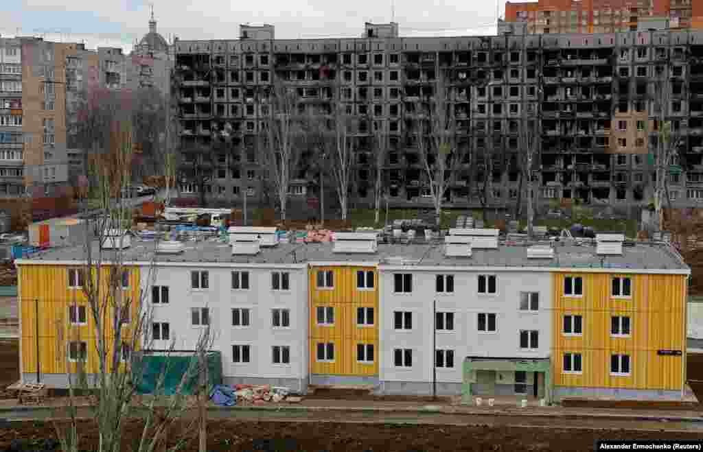 A new building in front of a war-ruined apartment block. Anti-Kremlin activist Aleksei Navalny’s investigative team has alleged that top Russian officials are profiting personally from reconstruction projects under way in Mariupol. 