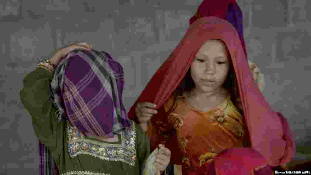  Afghan girls put on their scarfs at the refugee camp. At least 700 Afghans have been arrested since early September in Karachi alone -- 10 times more than in August -- and hundreds more in the other cities, according to official police figures.