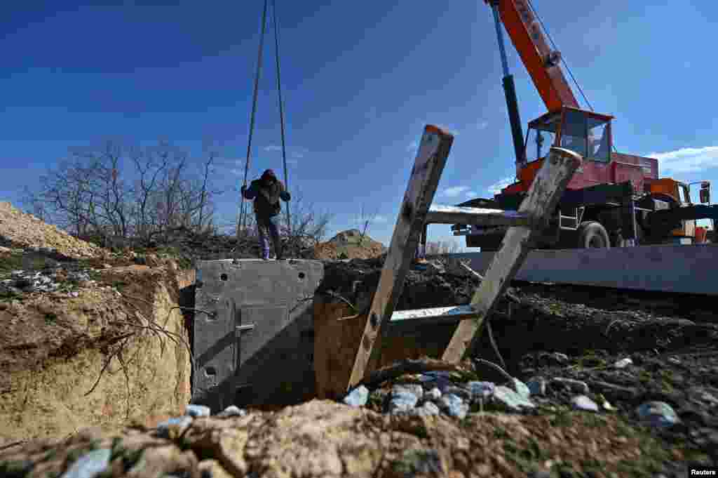 Workers install part of a massive concrete enclosure. Prime Minister Denys Shmyhal reported in January that Kyiv had allocated $466 million for the construction of fortifications, calling it a "record amount." 