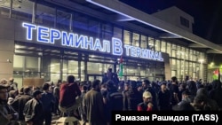 Натовп під терміналом аеропорту в Махачкалі скандує антиізраїльські гасла. Учасник тримає прапор Палестини. Дагестан, 28 жовтня 2023 року