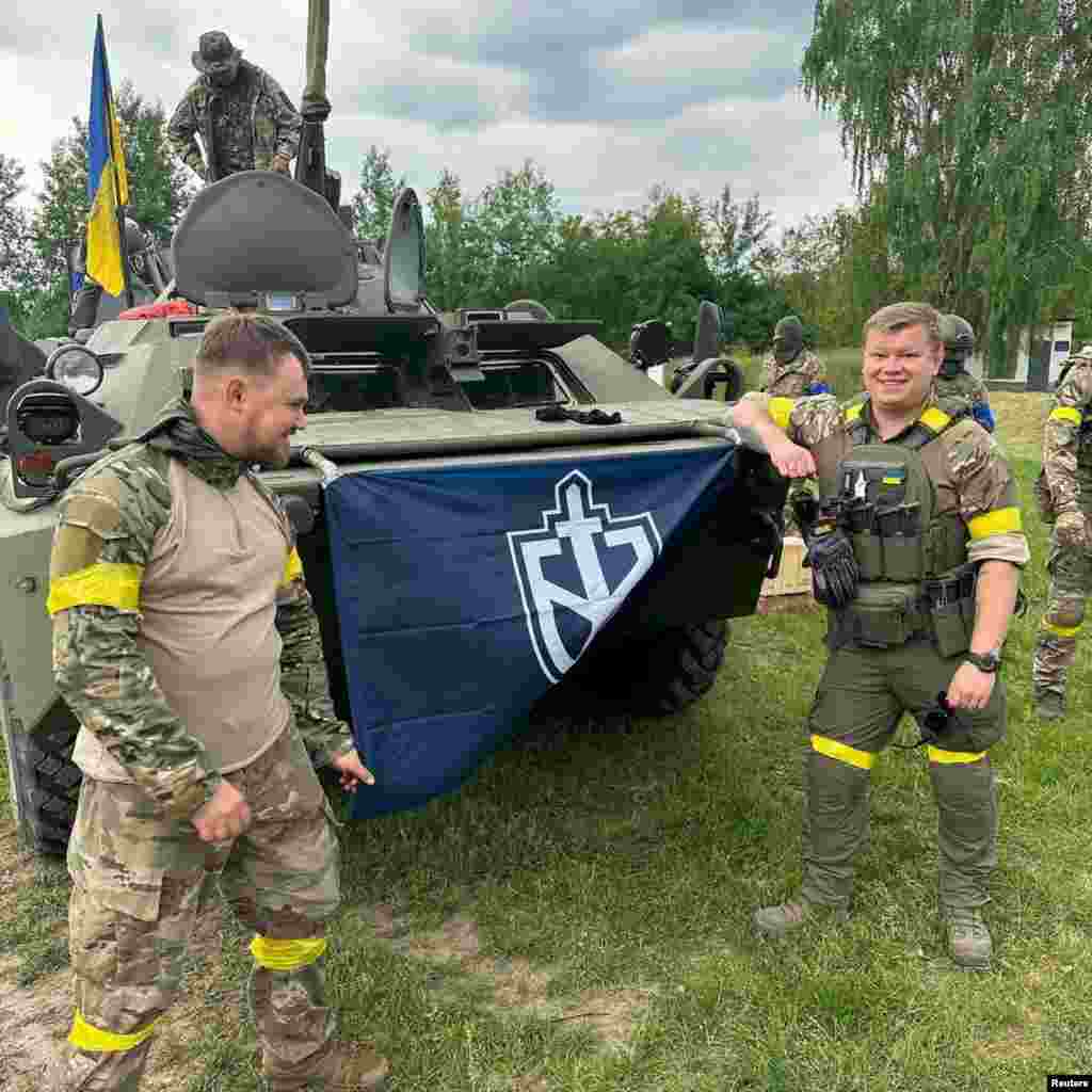 Members of the Russian Volunteer Corps display their flag in an image apparently taken inside Russian territory that was released on May 23. Michael Colborne, a journalist with the open-source investigative group Bellingcat, told Vice News that he immediately recognized some of the men allegedly involved in the raid as well-known neo-Nazis. "These are people who have literally organized Hitler worship nights, written poems about Hitler, and lead bands whose names and songs are about Hitler," he said.