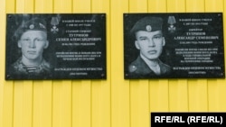 Memorial plaques on the school in the village of Kuratovo, where Semyon (left) and Aleksandr Tutrinov studied.