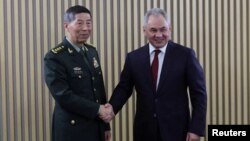 Russian Defense Minister Sergei Shoigu (right) shakes hands with his Chinese counterpart, Li Shangfu, during a meeting on the sidelines of a conference on international security in Moscow earlier this week. 