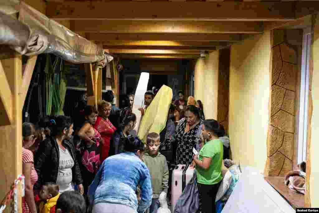 Donated mattresses are passed along as families with young children prepare to sleep for the night at the bus station. 
