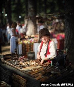 A man at a stall selling handmade knives.