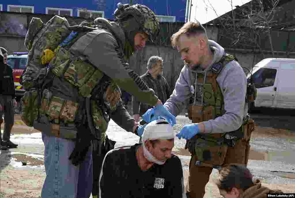 Medics apply first aid to an injured man. Oleh Synehubov, the regional governor, told national TV, "According to preliminary data, it was a cruise missile." 