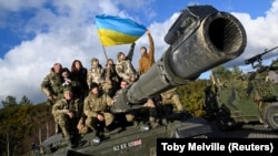 Ukrainian personnel pose with a flag on top of a Challenger 2 tank during training at Bovington Camp, near Wool in southwestern Britain, in February.