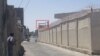 در عکس تسنیم، برجک کلانتری مشخص شده و یک نیروی لباس‌شخصی (چپ) اسلحه‌اش را به آن سمت نشانه رفته است