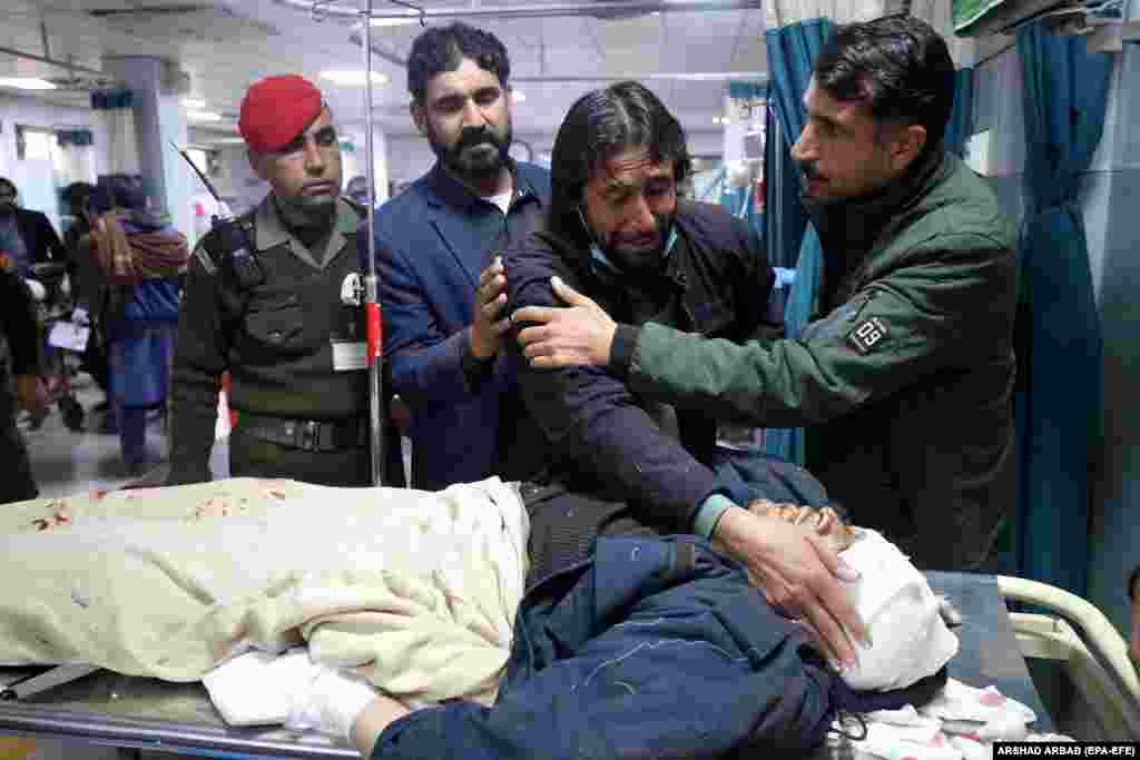 A relative caresses the face of a victim after he succumbed to his injuries following a roadside bombing that targeted a police vehicle near the Afghan border in Bajaur, a tribal district in Pakistan's Khyber Pakhtunkhwa Province, on January 8. The Tehrik-e Taliban Pakistan (TTP) militant group claimed responsibility for the blast, which killed at least seven people. Three police officers remain in critical condition.