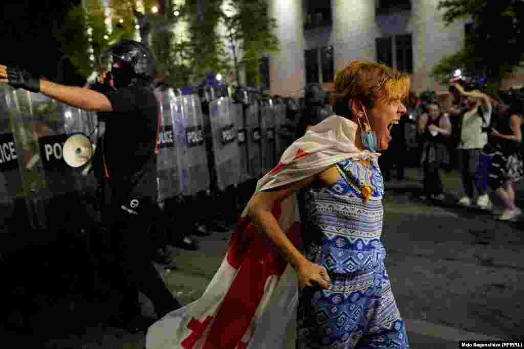 A protester draped in a Georgian flag shouts in front of a police cordon. The protests were a continuation of several weeks of rallies led by opposition parties and activist groups against the parliament’s advancement of the controversial draft law, which was passed in a first reading on April 17. 