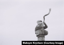 A soldier comrade of Kryvtsov's blows a ram's horn.