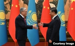 Toqaev greets Chinese President Xi Jinping in Beijing on October 17, 2023.