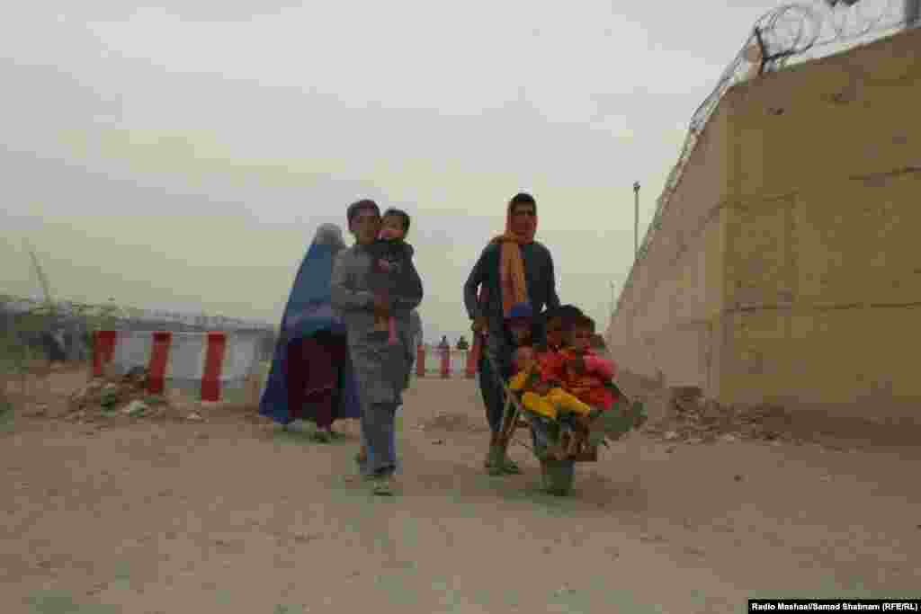 An Afghan boy ferries young children in a wheelbarrow at the border in Chaman, which is also known as the Friendship Gate. Pakistan is home to more than 4 million Afghan migrants and refugees, about 1.7 million of them undocumented, Islamabad says, although many have lived in Pakistan for their entire lives. 