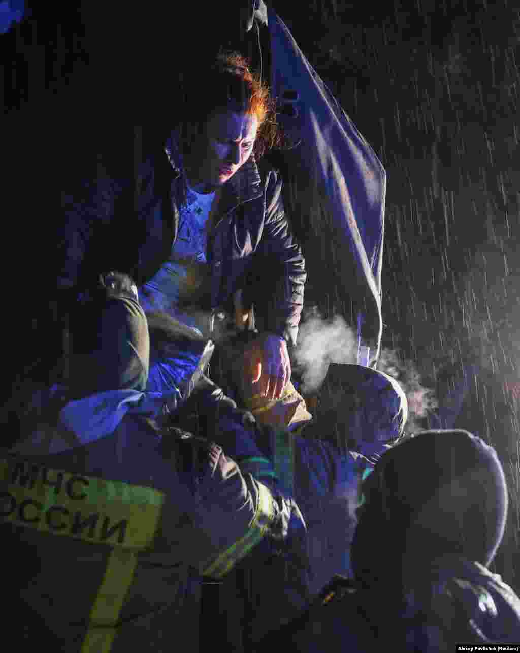 Residents are helped out of an evacuation truck during a heavy rainstorm. Kryuchkov added that nearly half a million people were without power and heat on the peninsula. 