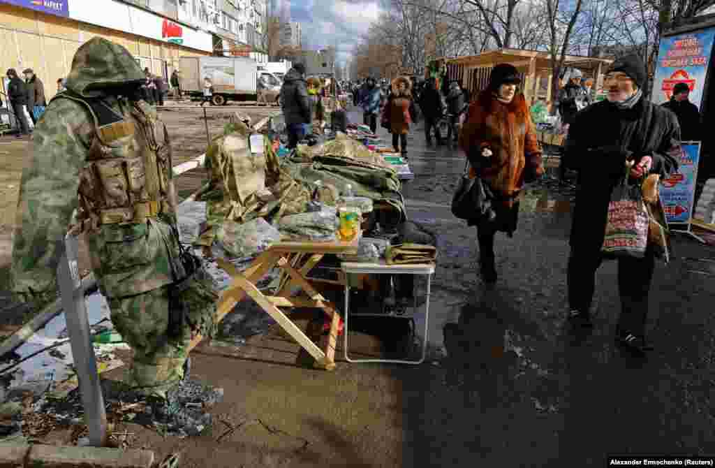 People shop at a makeshift market in Mariupol. 