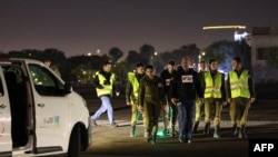 Israeli soldiers await the arrival of hostages by helicopter near Tel Aviv on November 30. Seniors, women, and children have been the priority so far in negotiations for the release of hostages.
