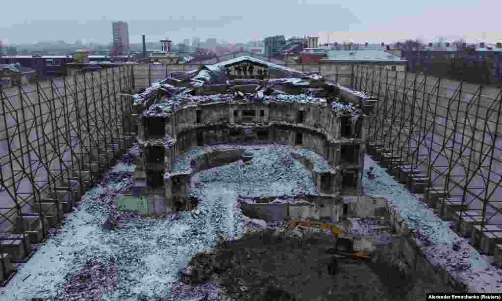 The ruined Donetsk Academic Regional Drama Theater, which was bombed on March 16, 2022, reportedly killing hundreds of civilians sheltering inside. Today, the ruined building is screened off by a tall fence decorated with images of Russian writers. 