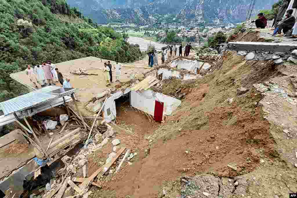 Residents gather at the site of a landslide in the remote area of Patrak in the Upper Dir district of Pakistan's Khyber Pakhtunkhwa Province on August 30. Twelve people died on August 30 when a landslide triggered by heavy rains destroyed their house, rescue officials said, with more than 300 killed since the start of the monsoon season.