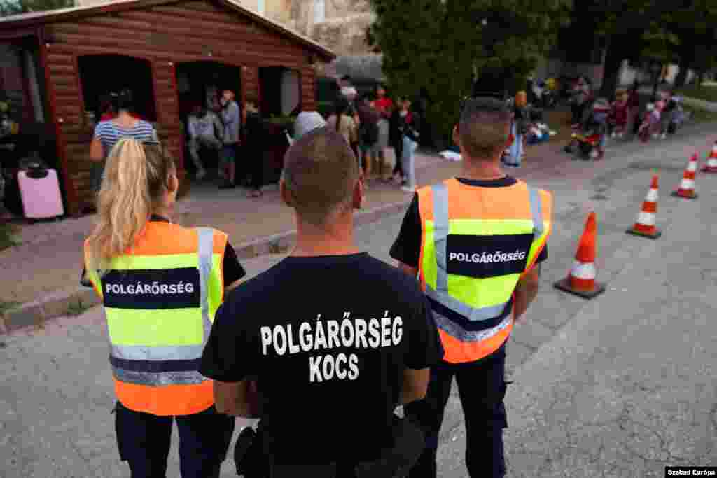 Refugees, under the watch of civil guards, set up camp near a bus station after being evicted from their temporary accommodation. 